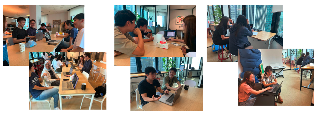 Several people working and collaborating at tables with laptops in a modern open office space.